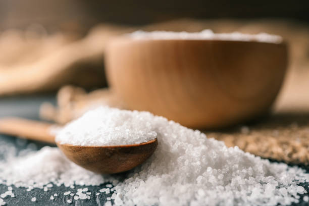 istock Pour salt into a wooden spoon, close-up 2158183831