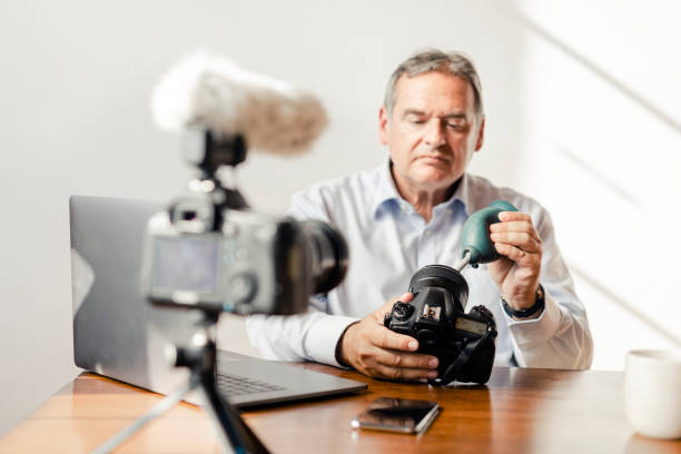 istock Man cleaning his camera lens with a rubber air blower 2158184202