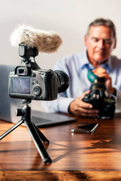 istock Man cleaning his camera lens with a rubber air blower 2158184206