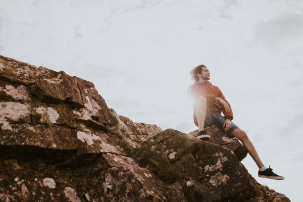 istock Man sitting on the edge of a cliff photo 2158185706
