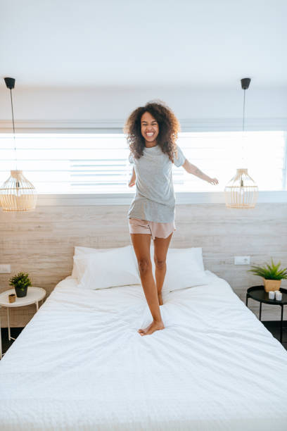 istock Funny woman standing on bed 2158187715