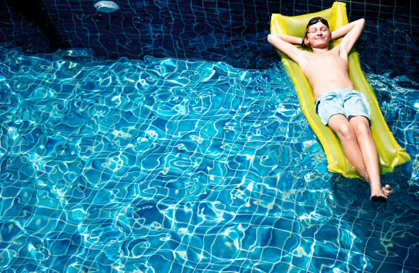 istock Teenage boy relaxing with pool mattress 2158188759
