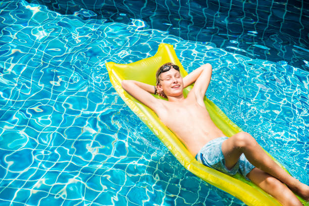 istock Teenage boy relaxing with pool mattress 2158188907