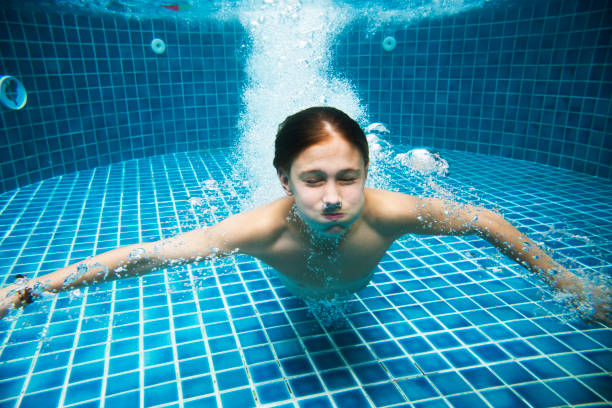 istock Young caucasian boy enjoying the pool underwater 2158189026