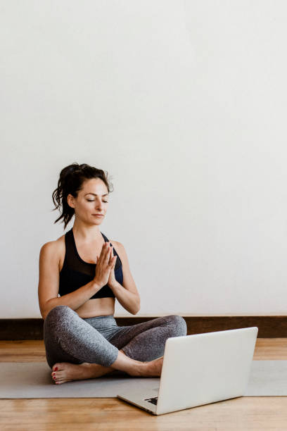 istock Active woman learning a yoga online via a laptop 2158192113