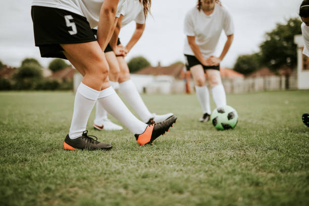 Mature woman stretching on a soccer and football field in a stadium