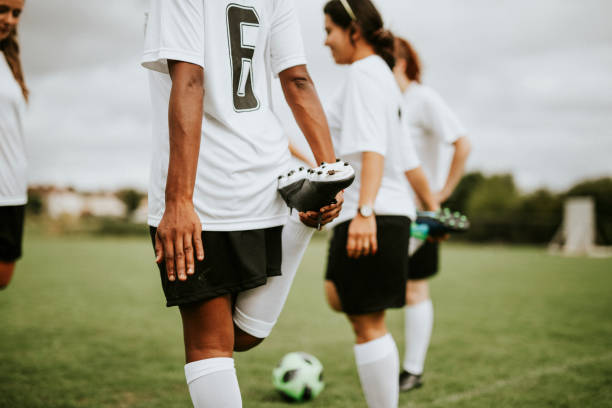 Female soccer team players stretching pre game
