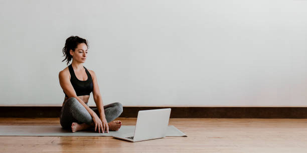 istock Active woman learning yoga online via a laptop 2158192138