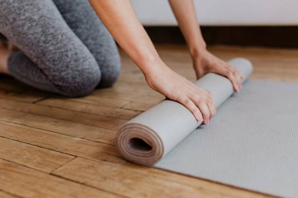 istock Sporty woman rolling a yoga mat 2158192193