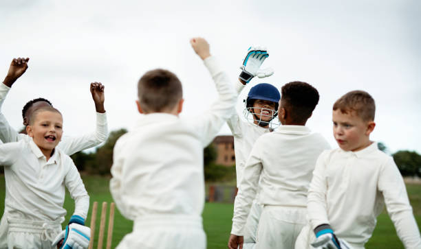 istock Young happy cricketers cheering on the field 2158192214