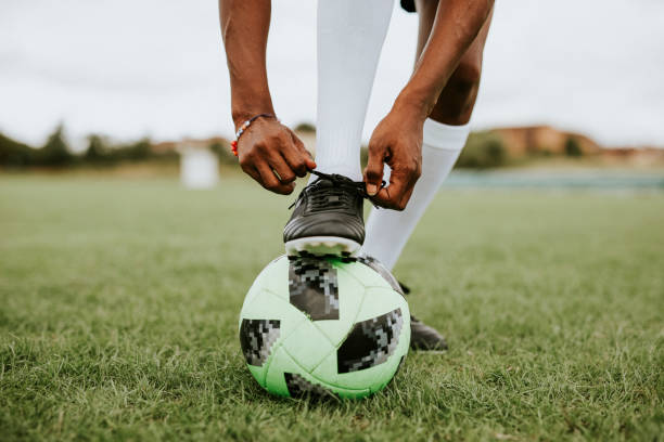 istock Football player tying her shoelaces 2158192243