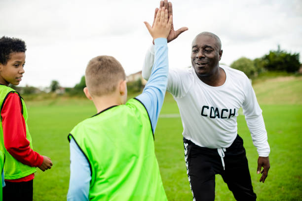 istock Football coach doing a high five with his student 2158192366