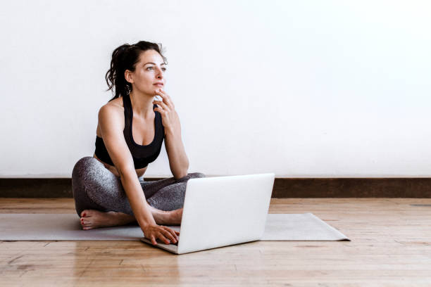 istock Active woman learning yoga online via a laptop 2158192389