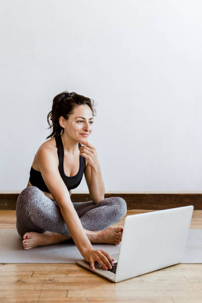 istock Active woman learning yoga online via a laptop 2158192391