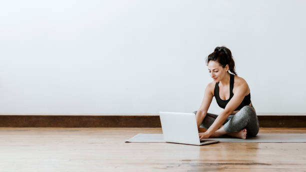 Active woman learning yoga online via a laptop