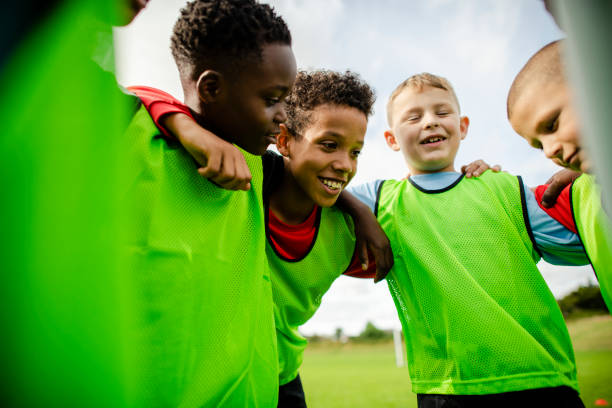 istock Junior football team huddling together 2158192403