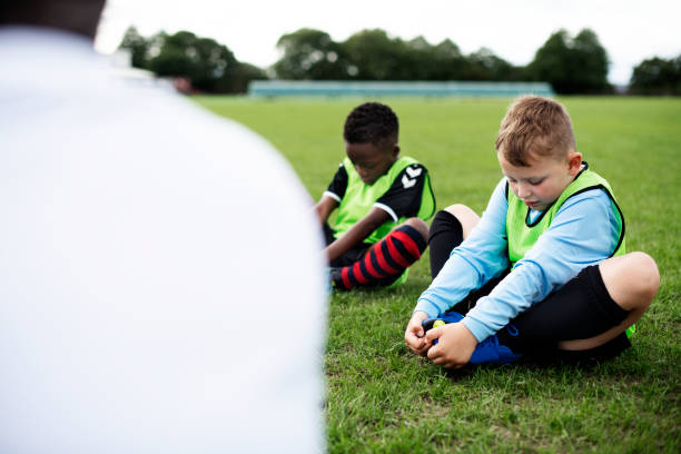 istock Young football kids stretching on the field 2158192537