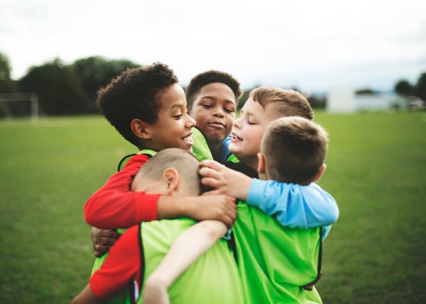istock Junior football team hugging each other 2158192542