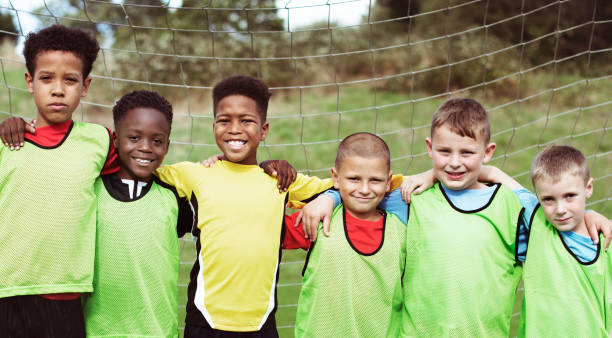 istock Happy junior football team standing together 2158193060