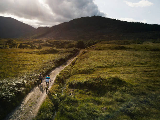 istock Couple cycling down a road in the Scottish Highlands 2158193733