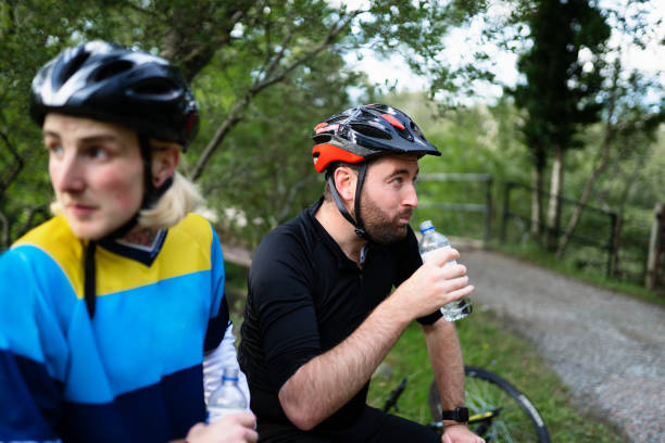 istock Cyclists resting and drinking water in the forest 2158193750