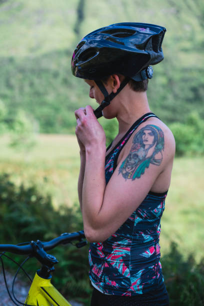 istock Cyclist putting on her bike helmet 2158193870