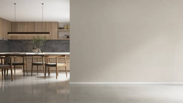 istock Blank beige wall to modern, luxury kitchen with dining table, chairs, wooden cabinet, cupboard, white top island and gray stone splash back 2158194088