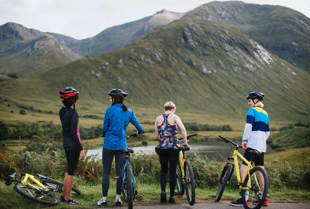 istock Group of cyclists by the riverside in the Highlands 2158194095