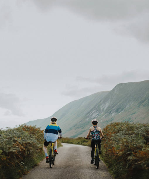 istock Couple cycling down a road in the Scottish Highlands 2158194111