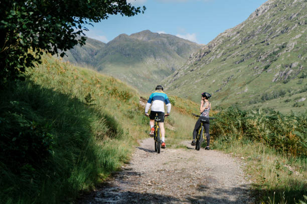 istock Couple cycling down a road in the Scottish Highlands 2158194316