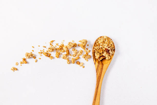 istock Granola in a wooden spoon and scattered on the table 2158194451