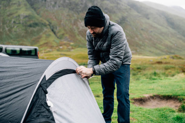 istock Man zipping up his tent in the raining 2158195251