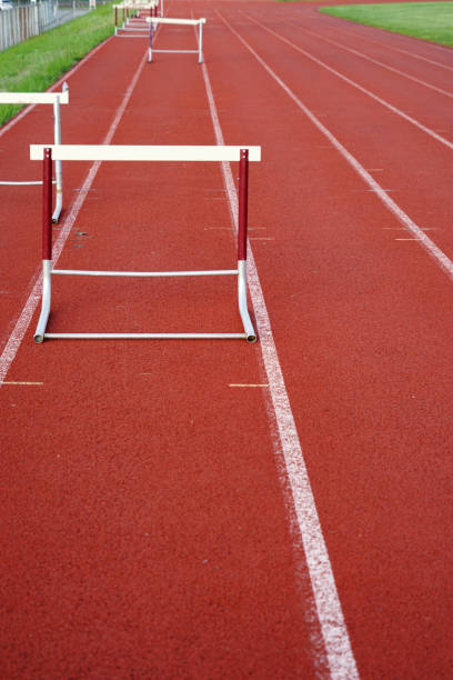 istock hurdles in a row on red sport field 2158197815