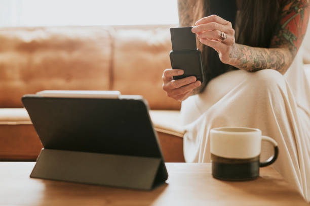 istock Woman using cashless payment card reader for her small business at home 2158197887