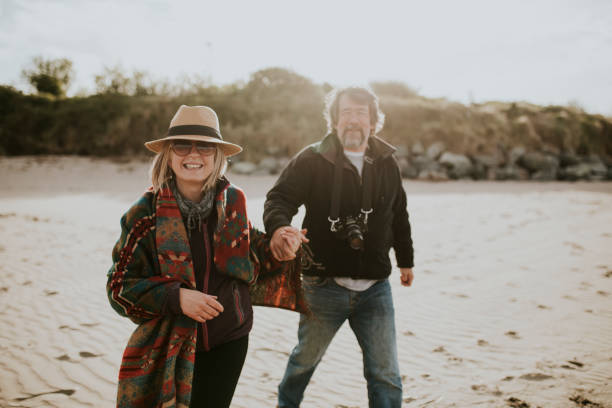 istock Happy retired couple take a stroll by the beach 2158198086