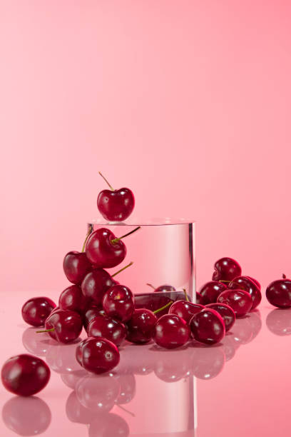 istock Plenty sweet cherries surround a circular platform in center, over pink background. Frontal shot photo has product displaying and advertising space 2158199293