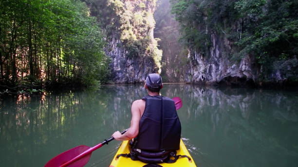Man leisurely navigates kayak admiring wild nature