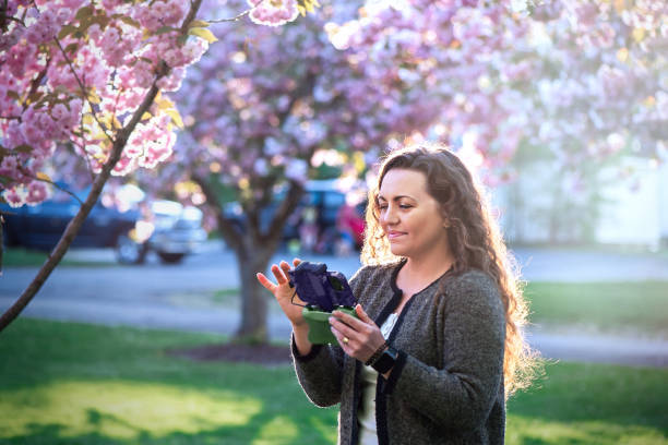 istock 35-year-old woman with long curly brown hair holding a drone controller. 2158200825