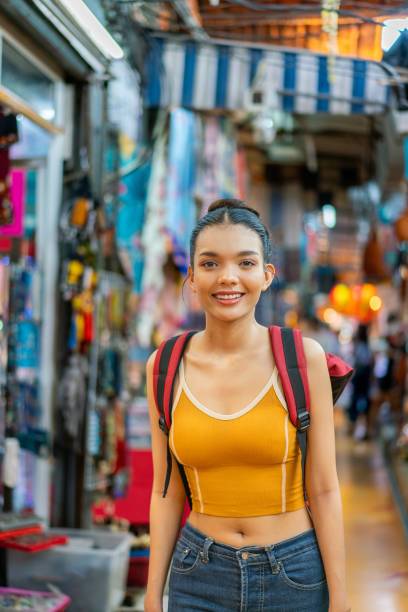 istock Happy Female Tourist Exploring Vibrant Weekend Market with Backpack 2158201090