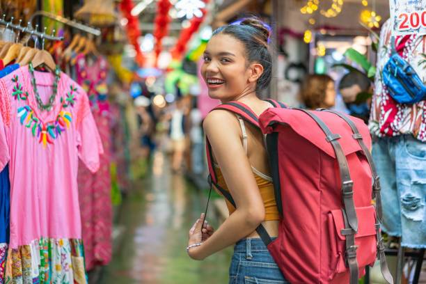 istock Happy Female Tourist Exploring Vibrant Weekend Market with Backpack 2158201172