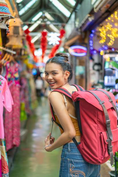 istock Happy Female Tourist Exploring Vibrant Weekend Market with Backpack 2158201189