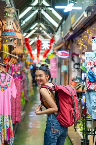 Happy Female Tourist Exploring Vibrant Weekend Market with Backpack
