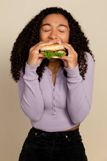 istock Woman enjoying a burger for lunch 2158202885