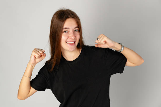 istock Young Woman Celebrating Success With a Joyful Gesture in a Studio 2158202978