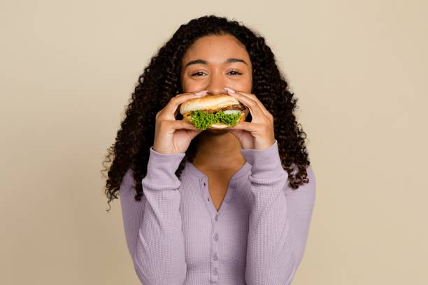 istock Woman enjoying a burger for lunch 2158203786