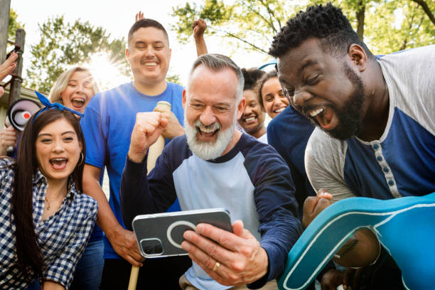 istock Supporters watching their team win the game on a mobile phone 2158204303