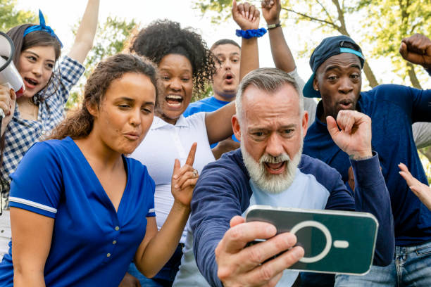 istock Supporters watching their team win the game on a mobile phone 2158204353