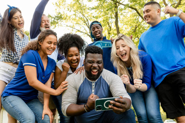istock Supporters watching their team win the game on a mobile phone 2158204363