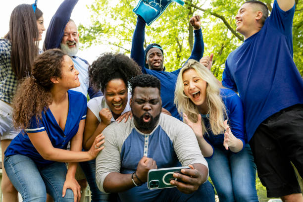 istock Supporters watching their team win the game on a mobile phone 2158204384