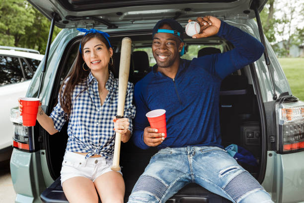 istock Friends sitting and drinking in the car boot at a tailgate party 2158204581